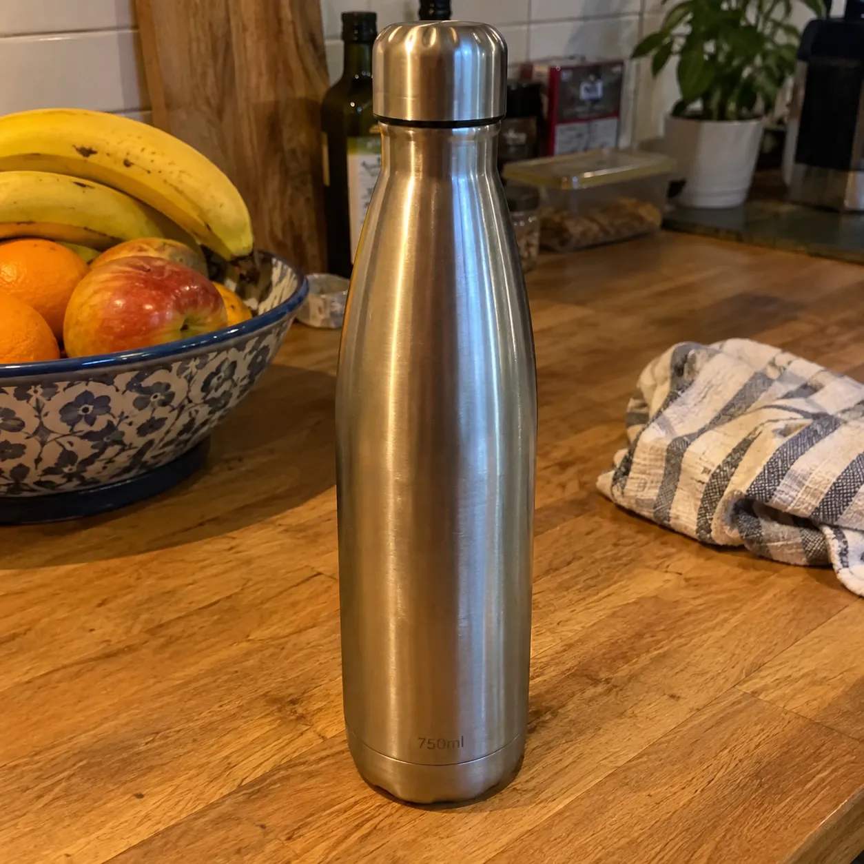Original snapshot of the water bottle on a kitchen counter next to a fruit bowl