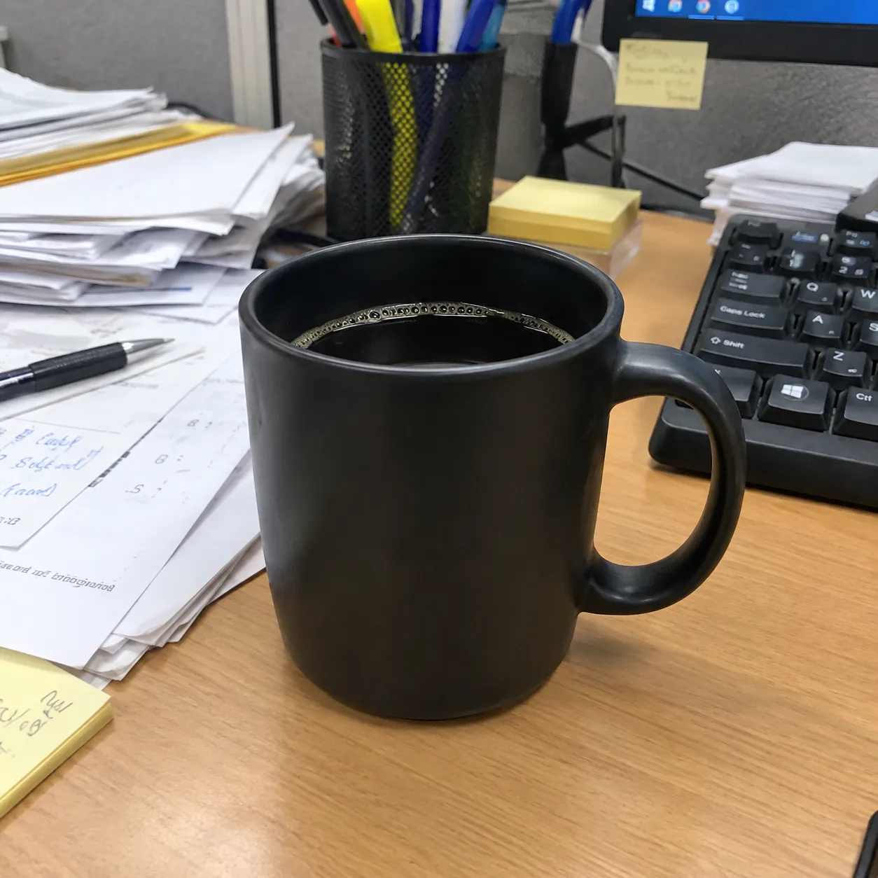 Original snapshot of the coffee mug on a cluttered office desk